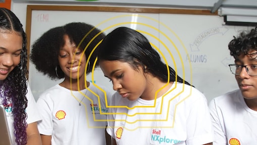 Quatro jovens reunidos à volta de um computador. Parecem concentrados e empenhados no mundo digital.