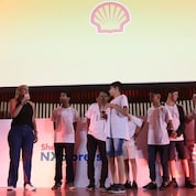 Na imagem, alunos da equipe Meninos de Ouro estão no palco da premiação.