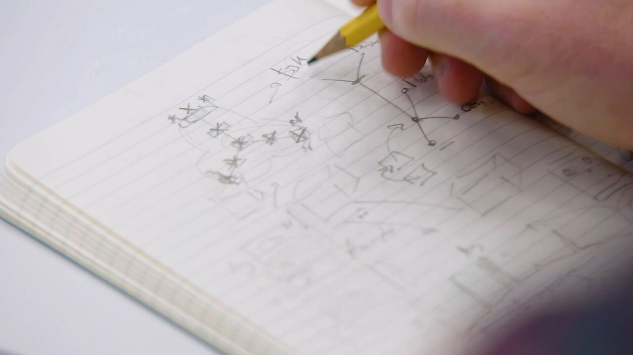 Caderno com anotações em lápis.