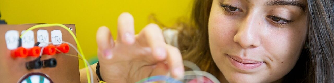 Estudante observa seu experimento desenvolvido em um projeto STEM.