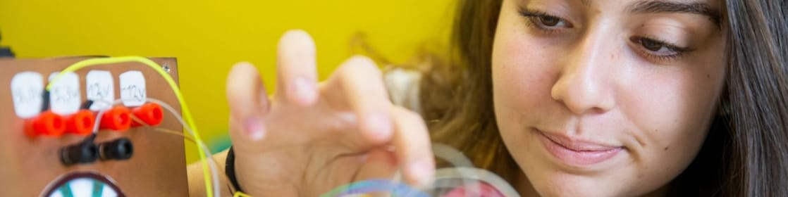 Estudante observa seu experimento desenvolvido em um projeto STEM.