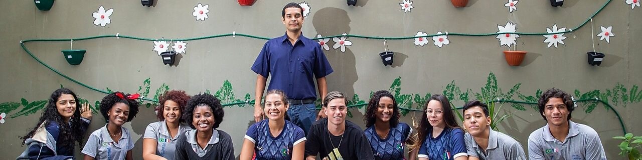Na foto, dez estudantes agachados, em frente ao projeto desenvolvido pelo grupo. Atrás dos estudantes temos o professor da turma.