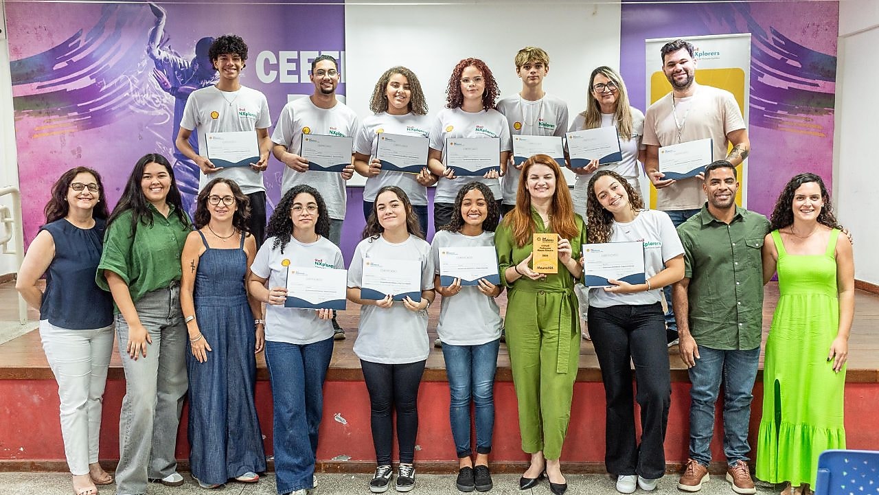 Um grupo de jovens com certificados nas mão, em um palco