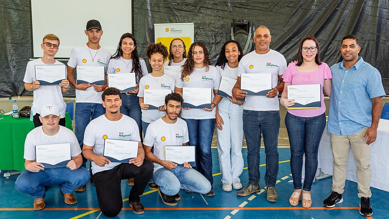 Um grupo de jovens posando para foto, em um ginásio esportivo