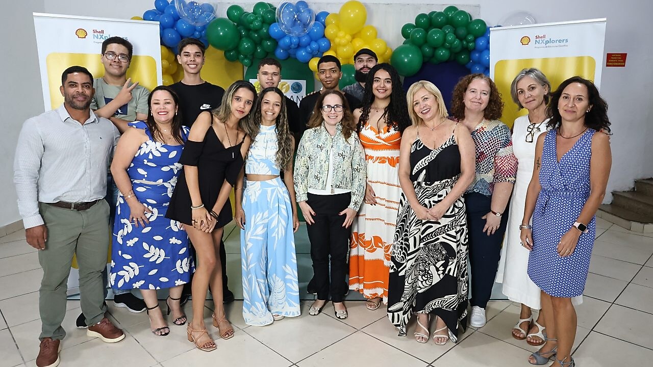 Um grupo de jovens em um fundo colorido, segurando uma placa de madeira