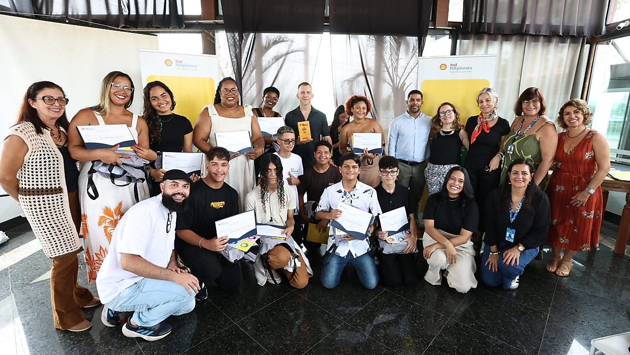 Grupo de jovens sorrindo e posando para a câmera em um evento ao ar livre