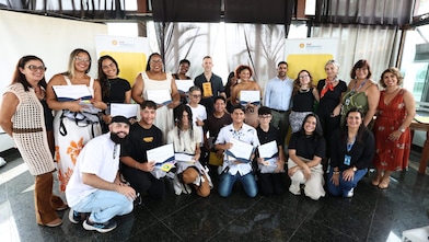 Grupo de jovens sorrindo e posando para a câmera em um evento ao ar livre